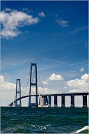 The Great Belt Fixed link (Danish: Storebæltsforbindelsen) is a multi-element fixed link crossing the Great Belt strait between the Danish islands of Zealand and Funen. It consists of five structures: a road suspension bridge and a railway tunnel between Zealand and the small island Sprogø located in the middle of the Great Belt, and a box girder bridge for both road and rail traffic between Sprogø and Funen. The "Great Belt Bridge" (Danish: Storebæltsbroen) commonly refers to the suspension bridge, although it may also be used to mean the box-girder bridge or the link in its entirety. The suspension bridge, officially known as the East Bridge, has the world's third longest main span (1.6 km), and the longest outside of Asia. It was designed by the Danish engineering firms COWI and Ramboll.