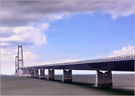 The Great Belt Fixed link (Danish: Storebæltsforbindelsen) is a multi-element fixed link crossing the Great Belt strait between the Danish islands of Zealand and Funen. It consists of five structures: a road suspension bridge and a railway tunnel between Zealand and the small island Sprogø located in the middle of the Great Belt, and a box girder bridge for both road and rail traffic between Sprogø and Funen. The "Great Belt Bridge" (Danish: Storebæltsbroen) commonly refers to the suspension bridge, although it may also be used to mean the box-girder bridge or the link in its entirety. The suspension bridge, officially known as the East Bridge, has the world's third longest main span (1.6 km), and the longest outside of Asia. It was designed by the Danish engineering firms COWI and Ramboll.